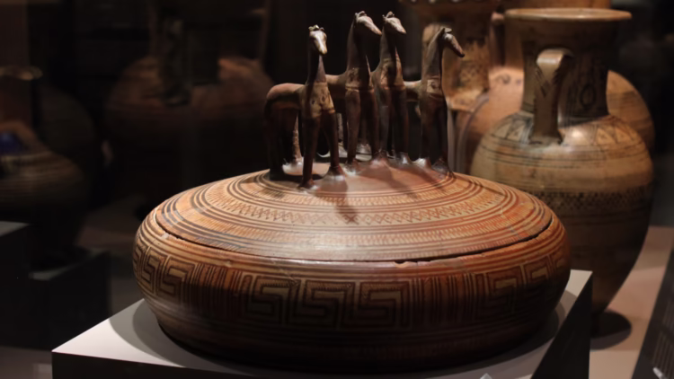 Large Attic pyxis with lid crowned by four horse figurines.